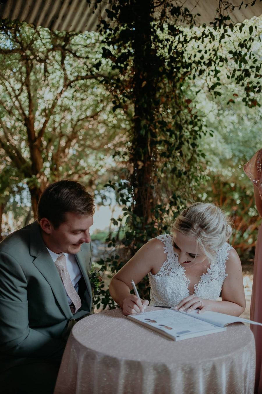 A couple signing the register at a small table in the garden