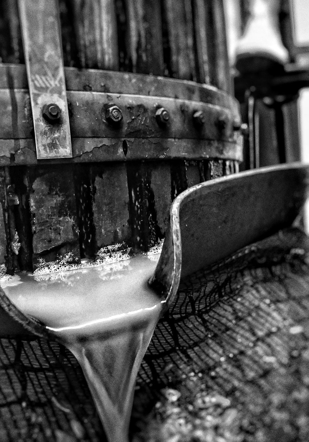Base wine running from the spout of a wooden basket press
