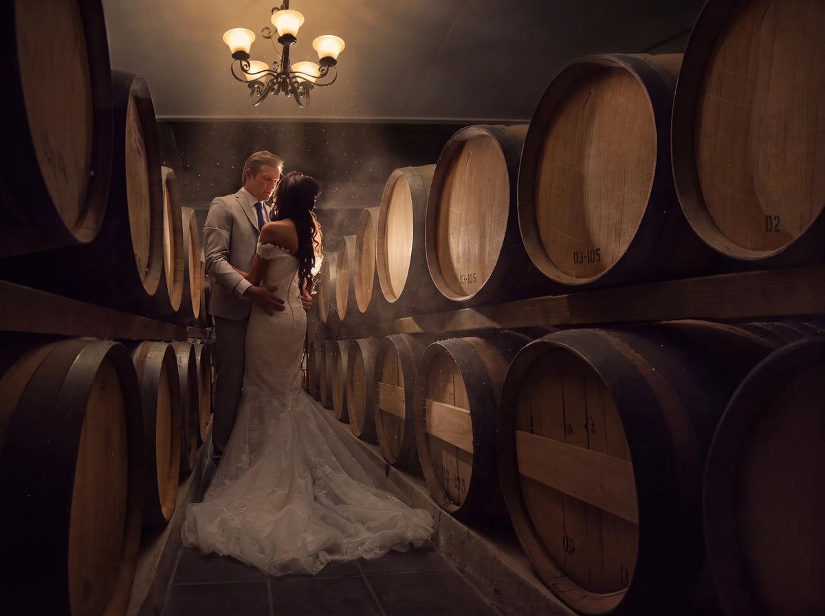 Newlyweds photographed among the barrels at Bezalel Estate