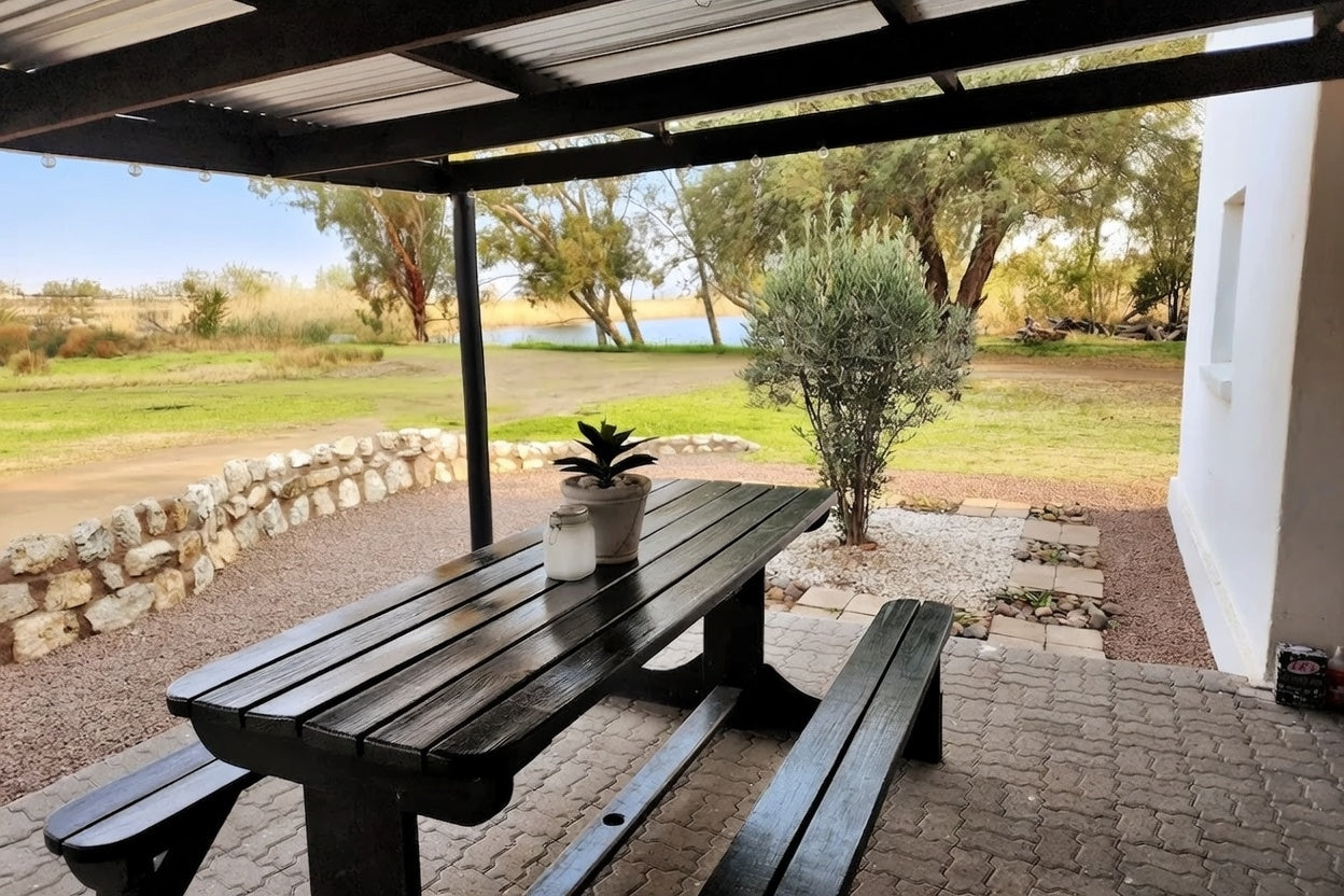 Picnic table under a covered outdoor area with a scenic background