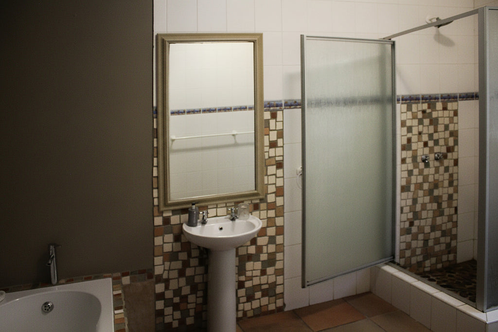 Bathroom with a shower, sink, and mirror.